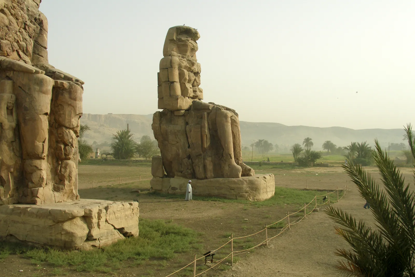 Memnonkolosserna på Thebes västra strand: två 18 meter höga statyer av Amenhotep III i kvartsit, vardera omkring 720 ton, som en gång vaktade hans försvunna gravtempel.