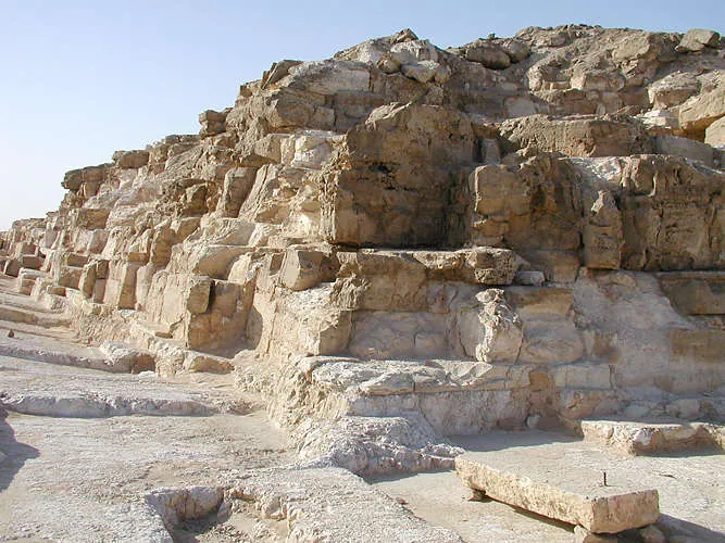 Djedefrepyramidens sydöstra hörn: beklädnadens grundstenar lutar cirka 12° inåt och planar ut mot hörnet, ett knep som gav granitblocken, huggna i 60–64°, en sidolutning på omkring 52°.