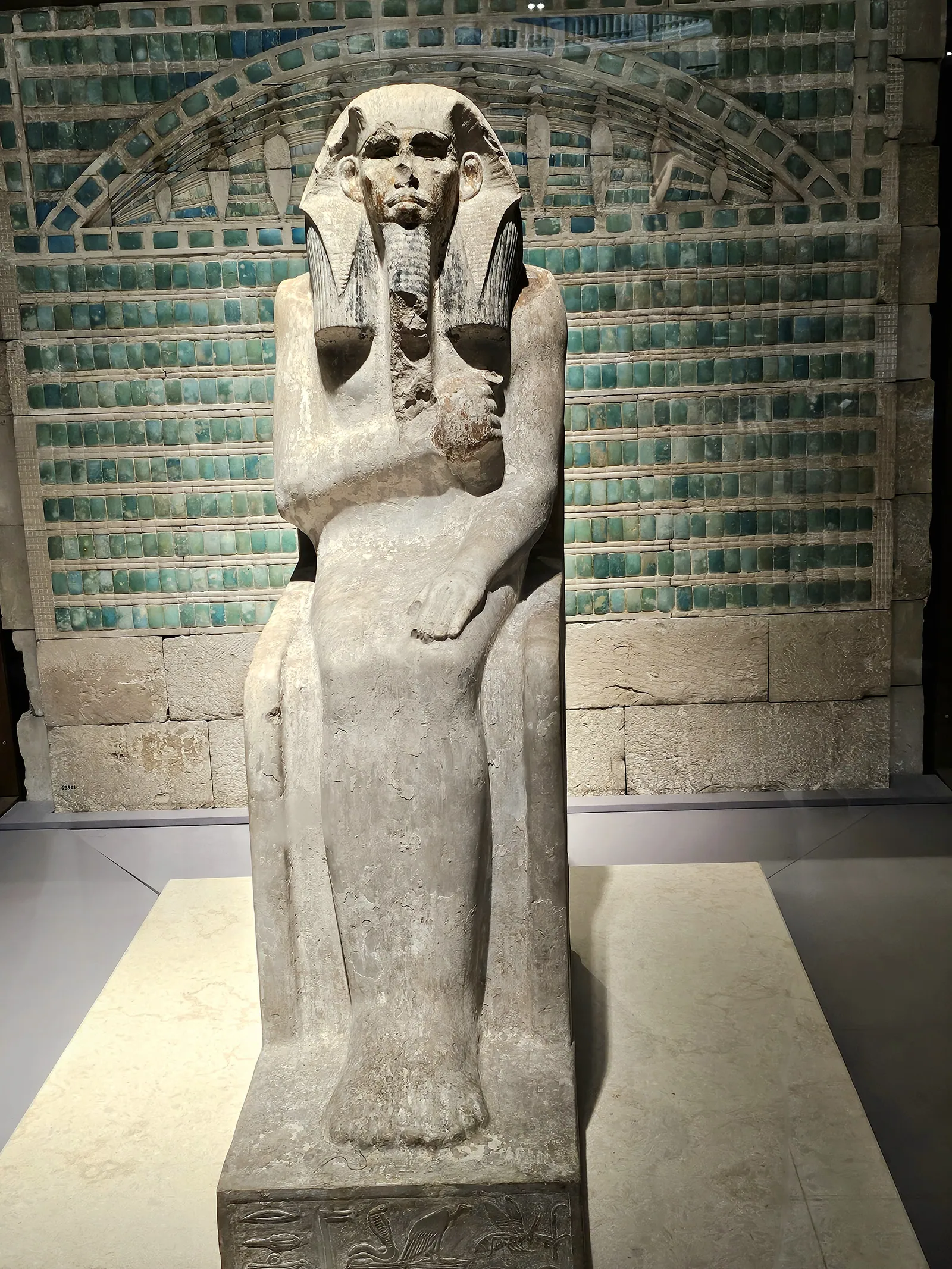 Den ursprungliga serdabstatyn av Djoser (JE 49158), den äldsta kända kungliga statyn i naturlig storlek, utställd framför blå plattor på Egyptiska museet vid Tahrirtorget (januari 2025).