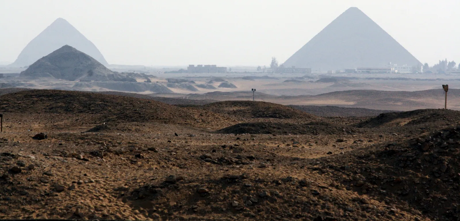 Från Djoserkomplexets södra ände mot Dahshur: Pepi II:s pyramid i vänstra förgrunden, Knäckta pyramiden bakom och Röda pyramiden till höger. Merenres hög ligger strax utanför bildkanten vid samma horisont.