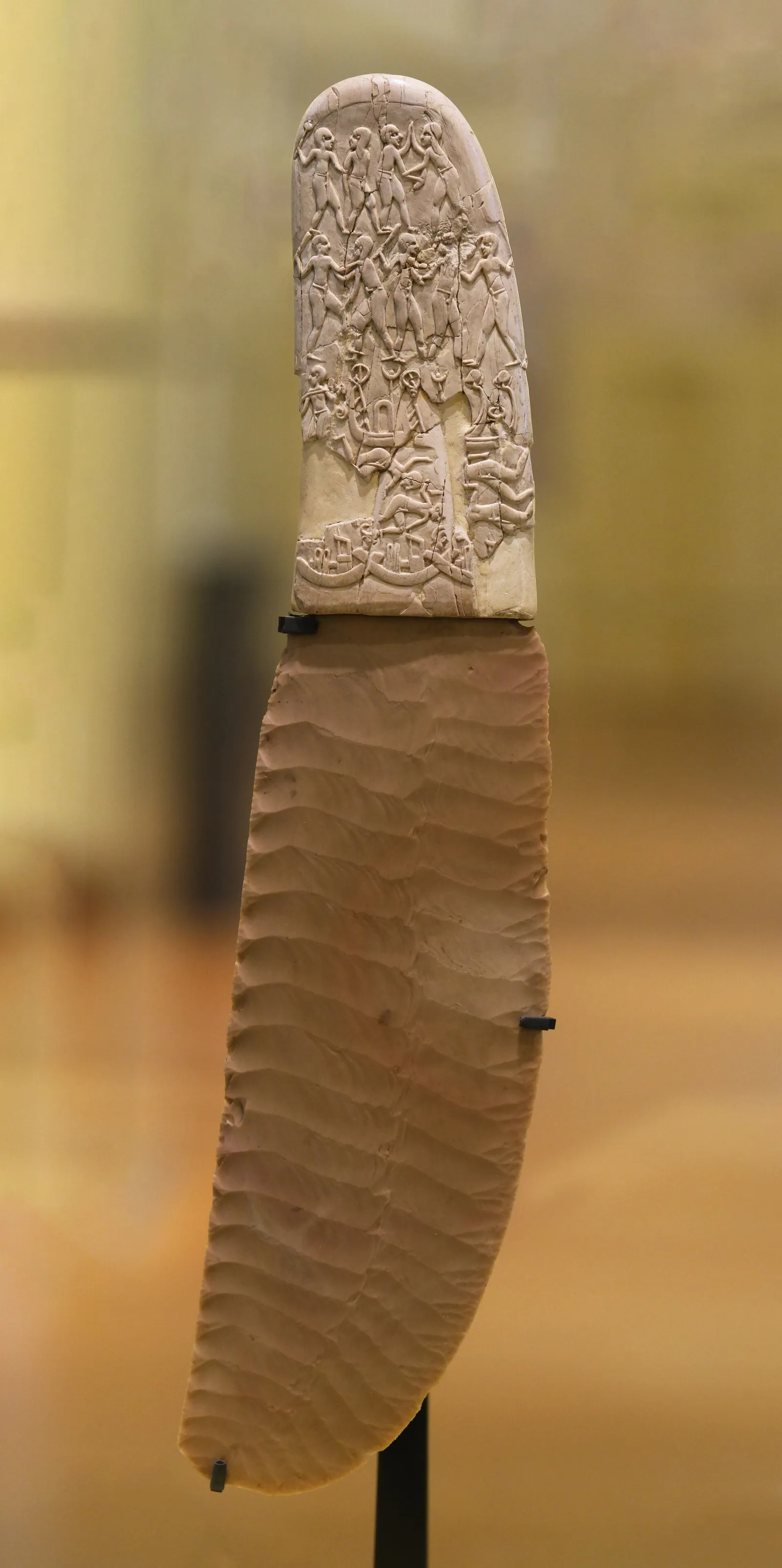 Gebel el-Arak-kniven (Louvren E 11517; sen Naqada II, ca 3400–3200 f.Kr.): ett vågmönstrat flintblad med ett snidat skaft av elfenben. På den här sidan griper en skäggig ”djurens herre” i mesopotamisk dräkt två lejon; på andra sidan pågår en strid på land och vatten. Köpt i Kairo 1914 och troligen från Abydos.