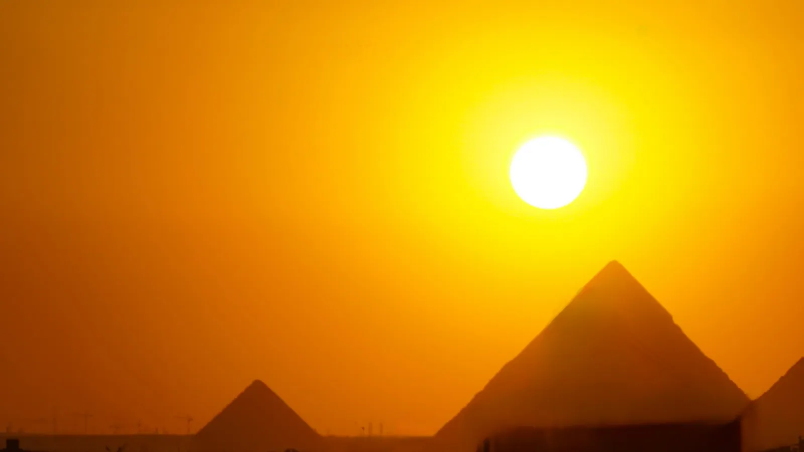 Solnedgång i Giza. Under resan går solen ner mellan 18.26 och 18.19 (sommartid, UTC+3) i bäringen 261°–258°; från hotellet glöder pyramidernas västsidor medan nordsidorna hamnar i skugga, och sedan följer den blå timmen med det upplysta GEM fram till omkring 18.50.