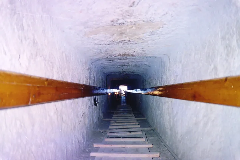 Inne i Menkaures pyramid (2006): den nedåtgående gången är klädd med granit där den går genom murverket och sedan uthuggen i berggrunden. Den löper ungefär 32 meter ner till den panelade förkammaren. Räkna med att gå hukande hela vägen.