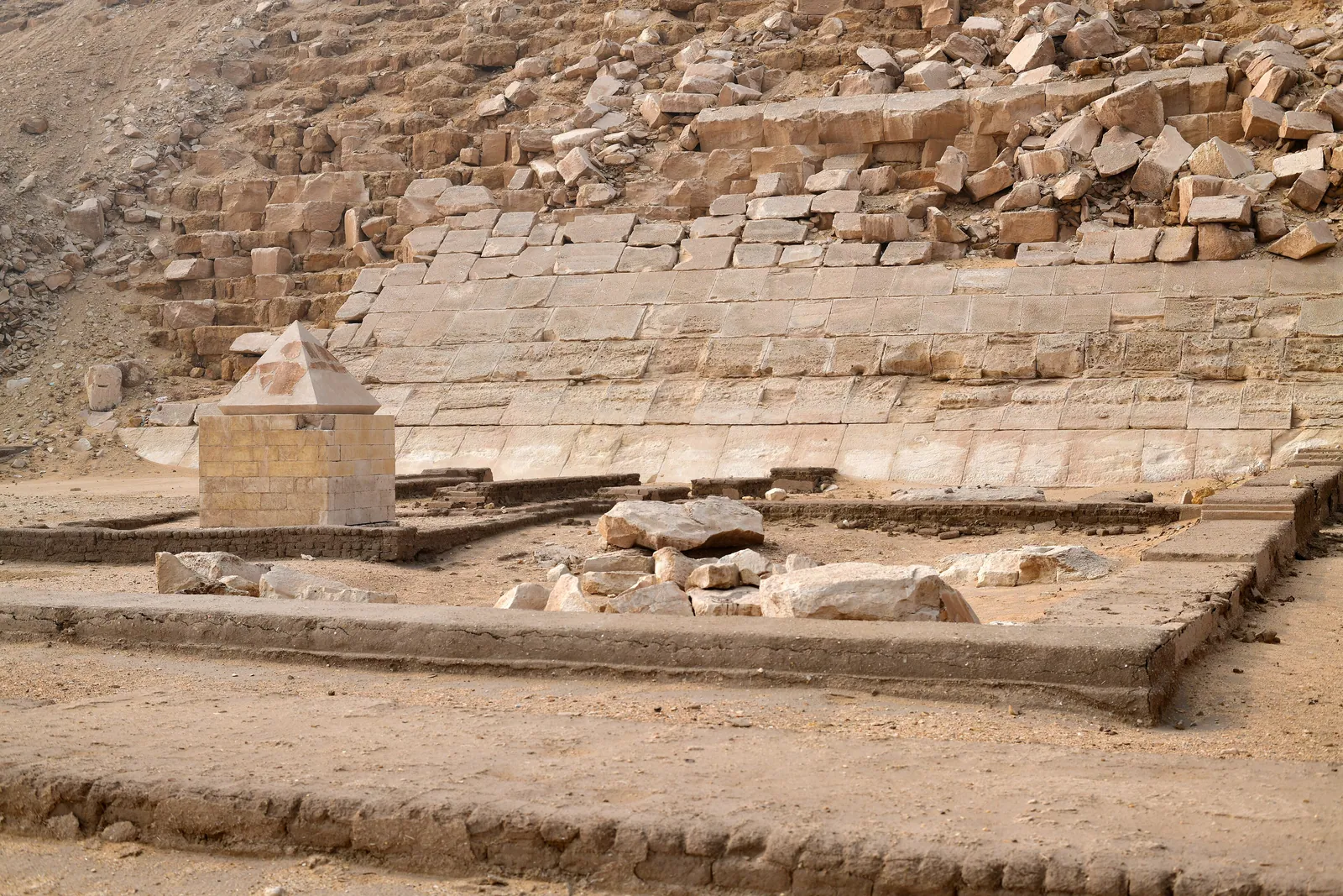 Den ihopfogade toppstenen av kalksten som Rainer Stadelmann hittade 1982 och som nu står utställd vid Röda pyramiden i Dahshur – toppstenen eller benbenet, den heliga spets som pyramid och obelisk delar.
