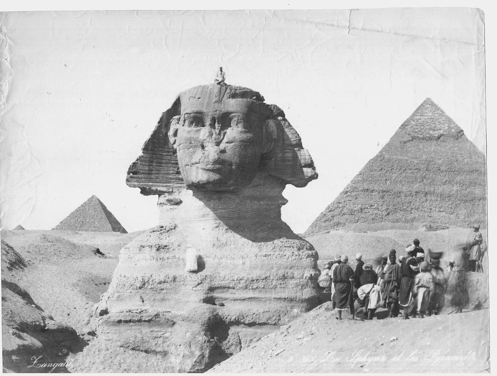 ”Le Sphynx et les Pyramides” – bröderna Zangaki, sent 1800-tal: ett sällskap besökare i sänkan framför Sfinxens bröst, med Chefrens pyramid bakom.